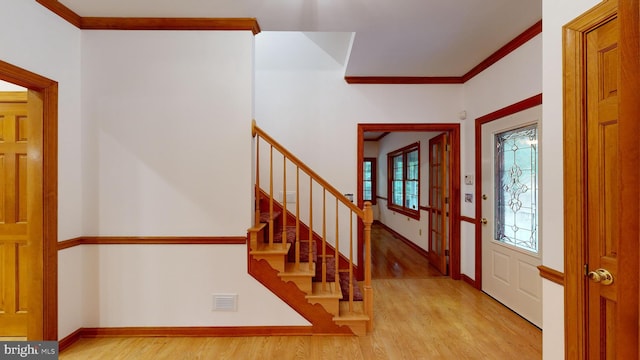 entrance foyer with light wood-type flooring and crown molding