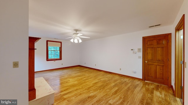 empty room with ceiling fan and light hardwood / wood-style floors