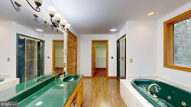 bathroom featuring wood-type flooring, vanity, separate shower and tub, and a wealth of natural light