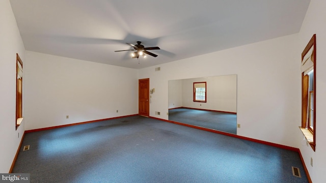 empty room featuring dark carpet and ceiling fan