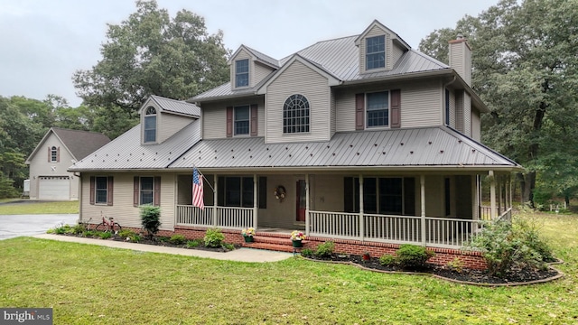 view of front of house with a garage, a front yard, and covered porch