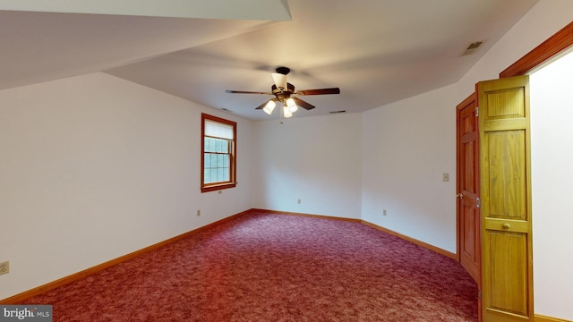 empty room featuring ceiling fan, carpet floors, and vaulted ceiling