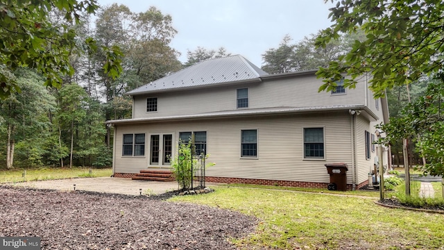 rear view of house featuring a lawn and a patio area