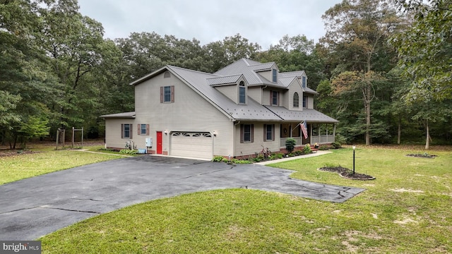 cape cod house with a front yard and a garage