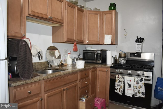 kitchen with stone counters, sink, and stainless steel appliances