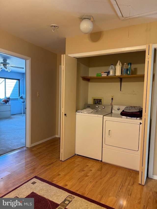 laundry room with washer and dryer, light hardwood / wood-style floors, and ceiling fan