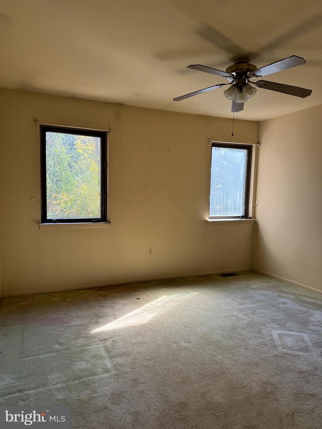 unfurnished room with light colored carpet and ceiling fan