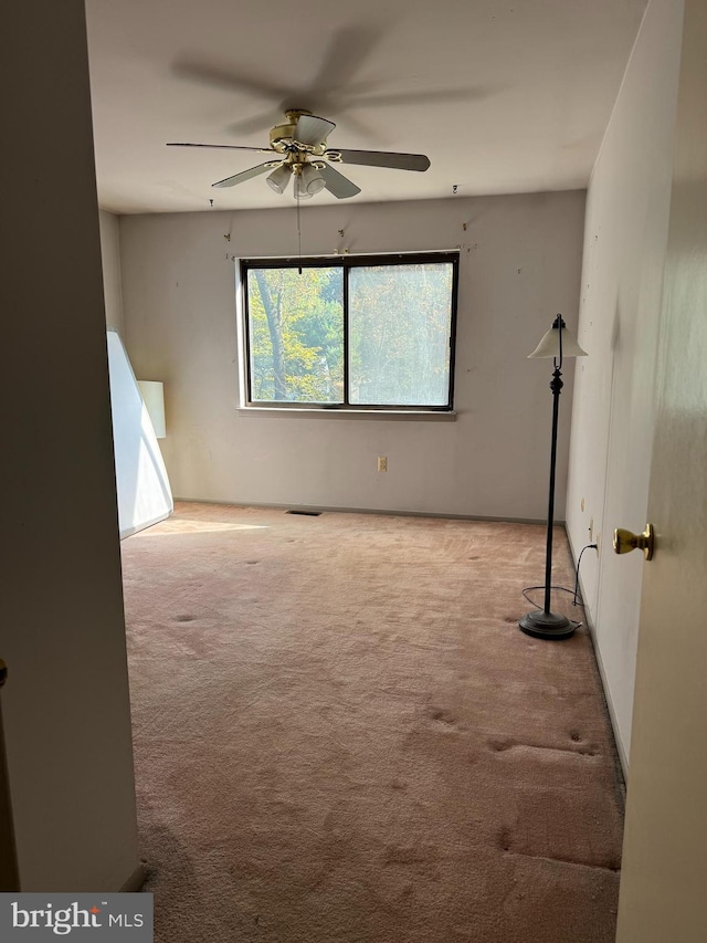 carpeted spare room featuring ceiling fan