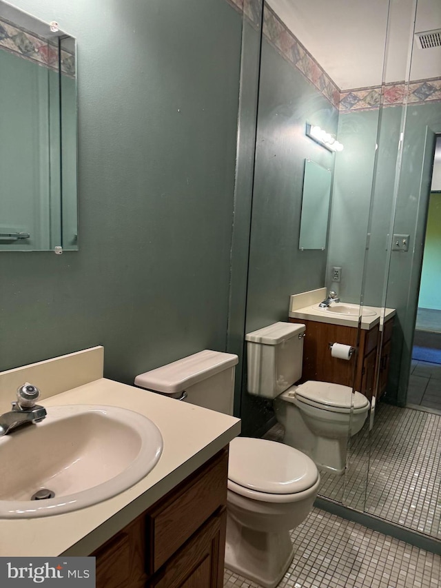 bathroom featuring toilet, vanity, and tile patterned flooring