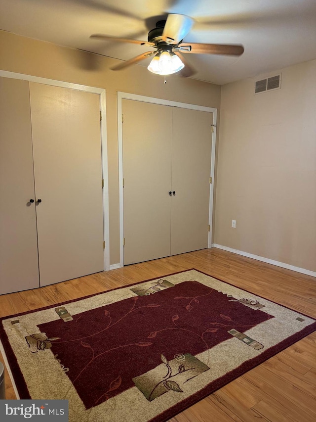 unfurnished bedroom featuring wood-type flooring and ceiling fan