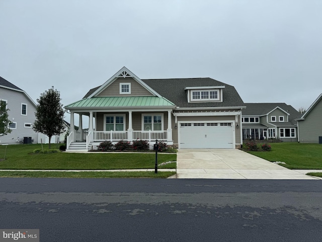 view of front of house with a front lawn, covered porch, and a garage