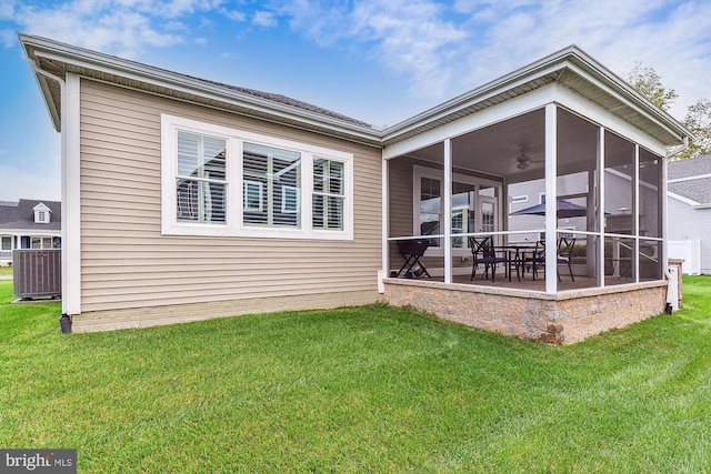 rear view of property with ceiling fan, a sunroom, a lawn, and a patio area