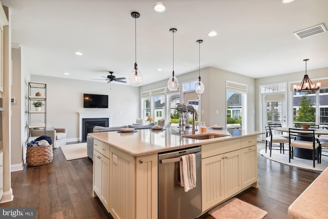 kitchen featuring dishwasher, dark wood-type flooring, a center island with sink, and sink