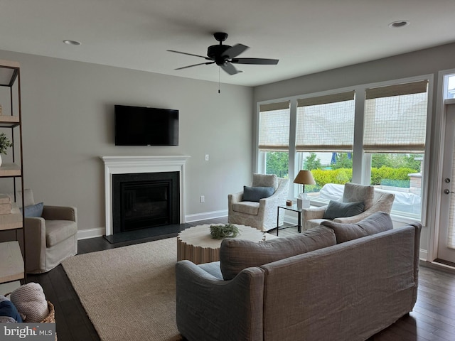 living room with ceiling fan and dark wood-type flooring