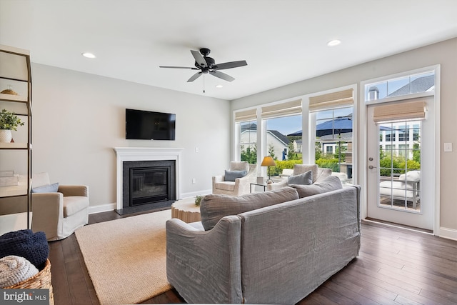 living room featuring ceiling fan and dark hardwood / wood-style floors