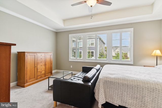 bedroom with crown molding, ceiling fan, a raised ceiling, and light colored carpet