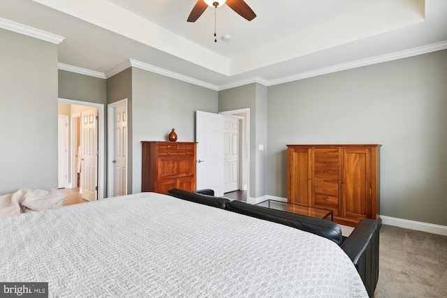 carpeted bedroom with a raised ceiling, ornamental molding, and ceiling fan