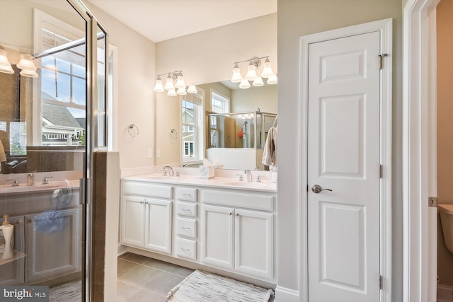 bathroom featuring tile patterned flooring, a shower with door, and vanity