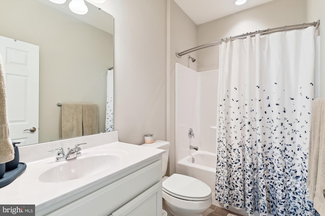 full bathroom with vanity, shower / tub combo, and toilet