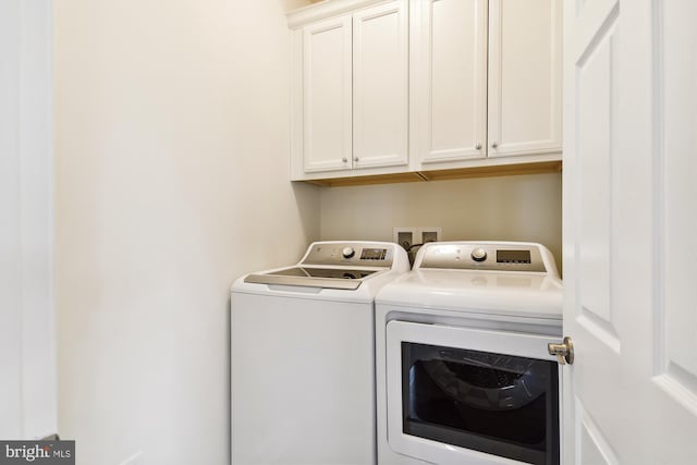 laundry area with washer and dryer and cabinets