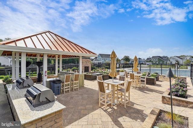 view of patio / terrace with area for grilling, grilling area, a pool, a gazebo, and a water view