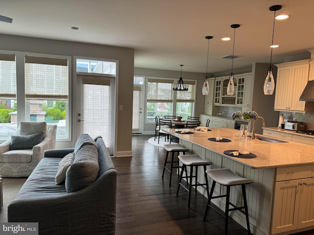 kitchen featuring light stone counters, hanging light fixtures, and a wealth of natural light