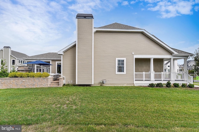 view of side of property with a porch and a lawn