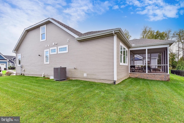 back of property with central air condition unit, a yard, and a sunroom