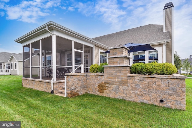 back of property featuring a yard and a sunroom