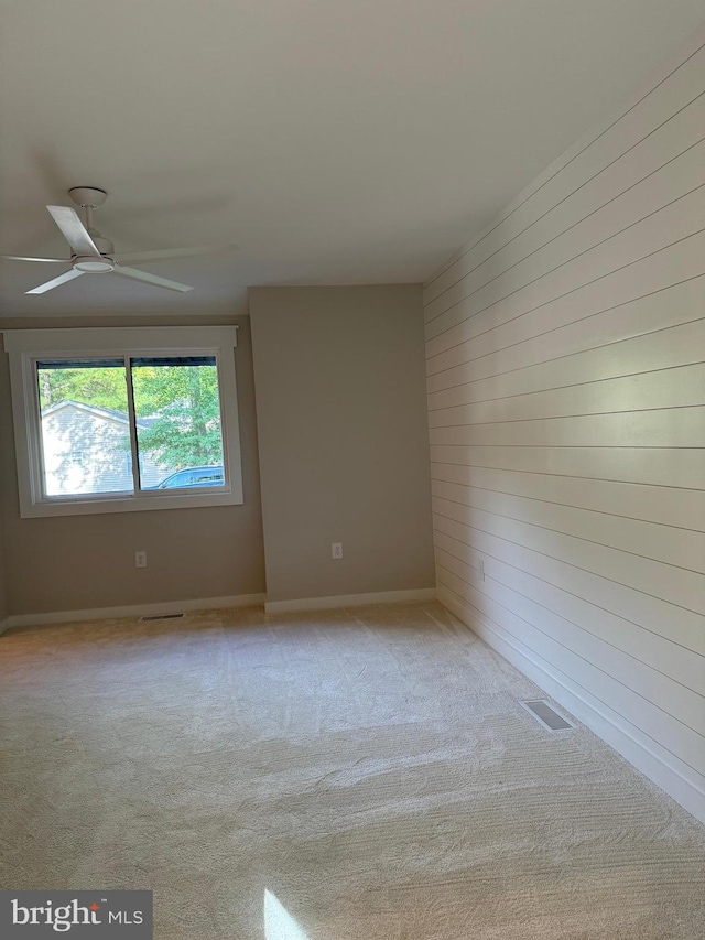 spare room with light colored carpet and ceiling fan