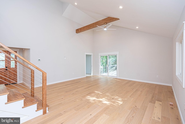 unfurnished living room featuring beam ceiling, high vaulted ceiling, light wood-type flooring, and ceiling fan