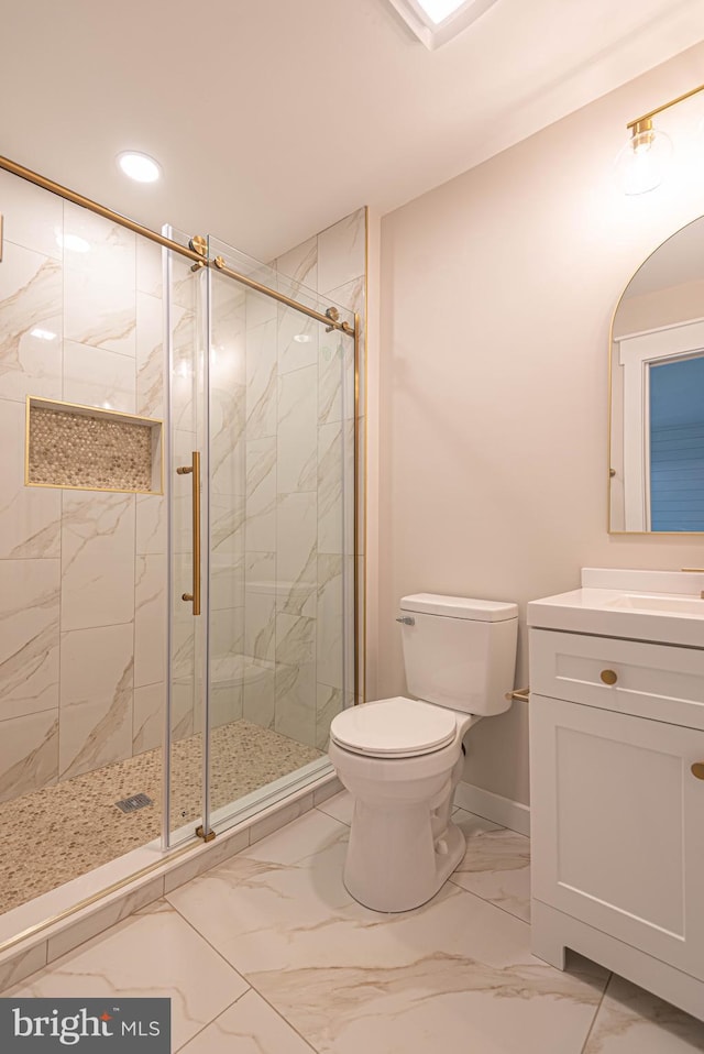 bathroom featuring vanity, toilet, and a shower with shower door