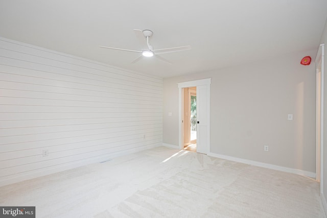 carpeted spare room with ceiling fan