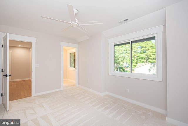 unfurnished bedroom with light carpet and ceiling fan