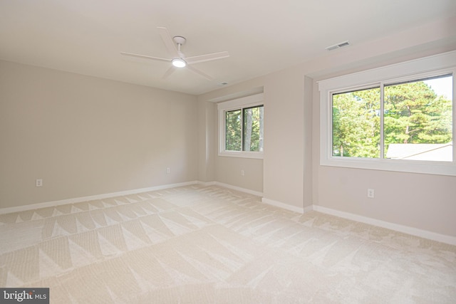 unfurnished room featuring light colored carpet and ceiling fan