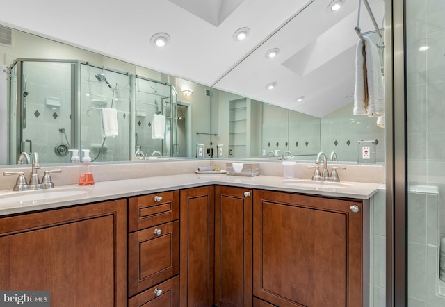 bathroom with lofted ceiling, a shower with door, and vanity