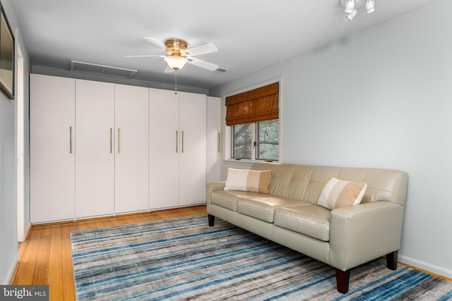 living room featuring wood-type flooring and ceiling fan