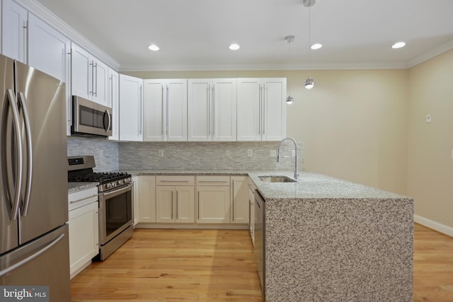 kitchen featuring light hardwood / wood-style flooring, kitchen peninsula, appliances with stainless steel finishes, and hanging light fixtures