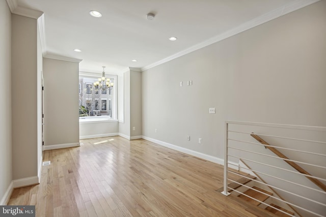 unfurnished living room with a notable chandelier, ornamental molding, and light hardwood / wood-style flooring