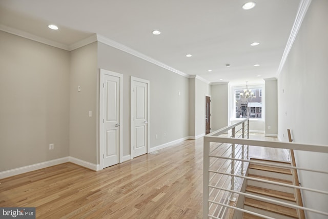 unfurnished room with light wood-type flooring, crown molding, and an inviting chandelier