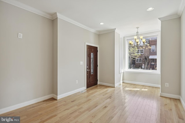 entrance foyer with light wood-type flooring, a notable chandelier, and ornamental molding