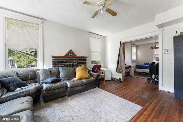 living room featuring a textured ceiling, a healthy amount of sunlight, ceiling fan, and dark wood-type flooring