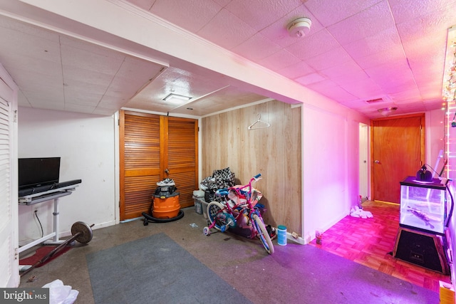 game room with wooden walls and parquet flooring