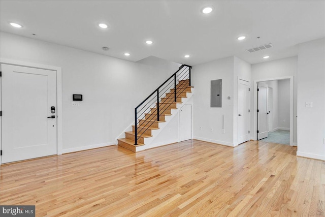 foyer entrance with light hardwood / wood-style floors and electric panel