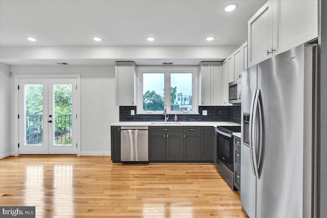 kitchen with sink, appliances with stainless steel finishes, light hardwood / wood-style flooring, and french doors