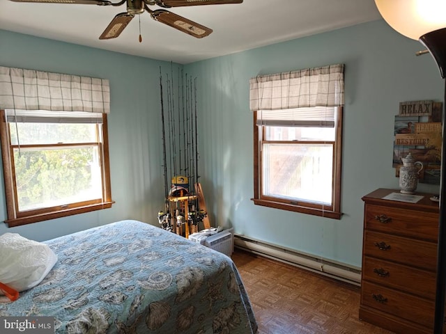 bedroom featuring a baseboard heating unit, parquet flooring, and ceiling fan