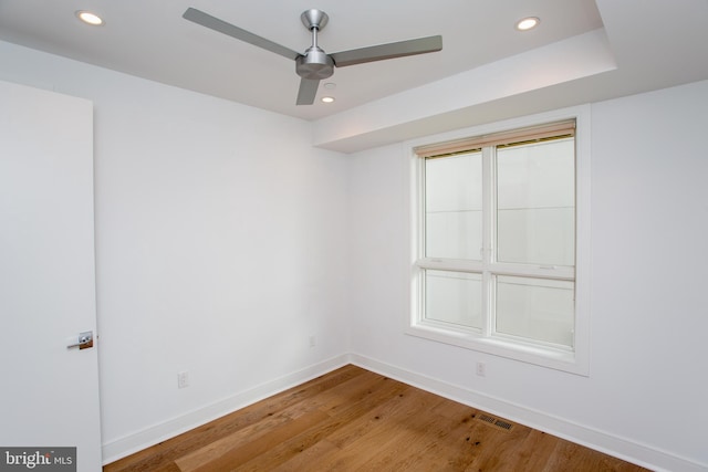 spare room with ceiling fan, plenty of natural light, and hardwood / wood-style floors