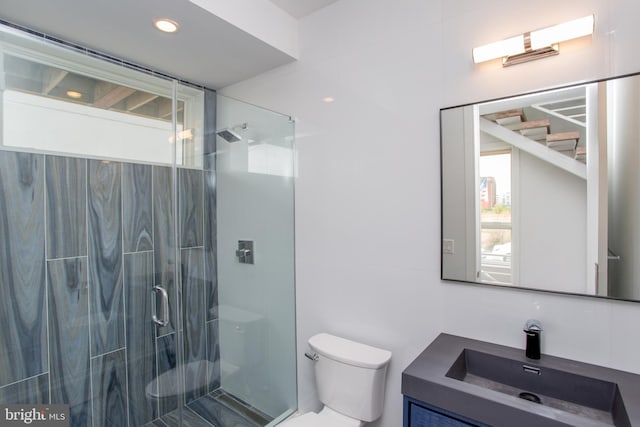 bathroom with vanity, a shower with shower door, and toilet