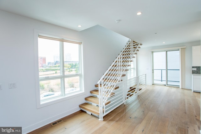 stairs featuring hardwood / wood-style floors