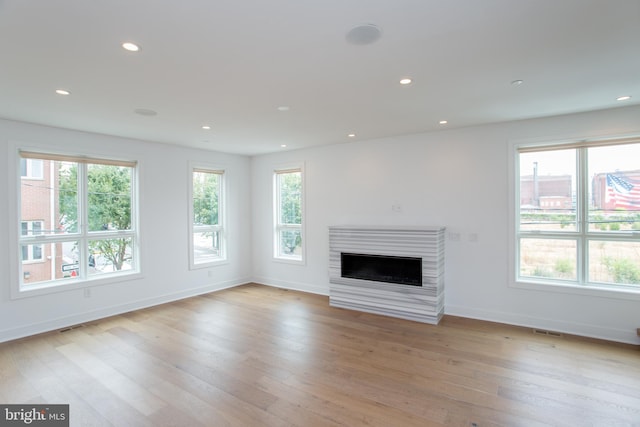 unfurnished living room featuring light wood-type flooring and plenty of natural light